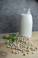 Pouring bio soy milk on rustic wood dark background