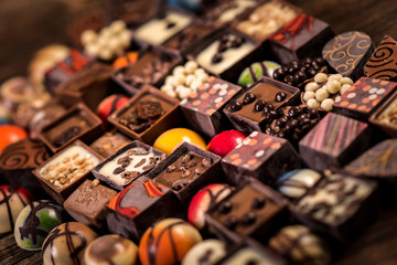 Assorted chocolate pralines on the wooden background