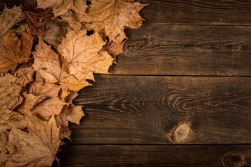 fallen dry leaves on wooden plank background