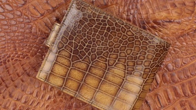 Close-up. Rotation of beautiful male wallet lying on a brown leather.