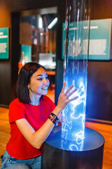  Woman visitor looking at Colorful plasma lamp experiment in physics museum © EdNurg