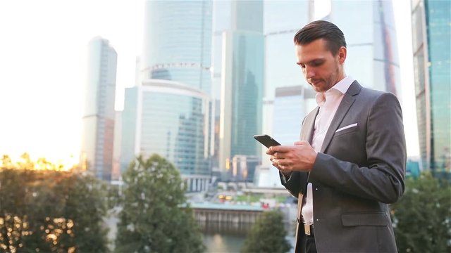 Young caucasian man holding smartphone for business work.