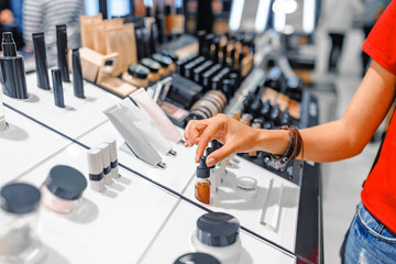 woman chooses cosmetics and make-up products in a store © EdNurg