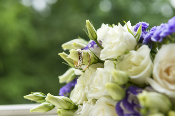 wedding bouquet of white roses with wedding rings on a green background, bride's bouquet, flowers