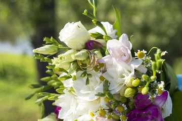 bridal bouquet of bride with gold wedding rings