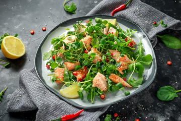 Fresh Salmon salad in asian style with sesame seeds, chili, lemon and green vegetables