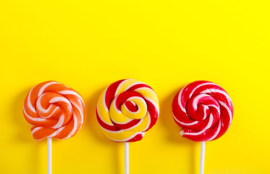 Colorful swirl lollypops  over yellow paper