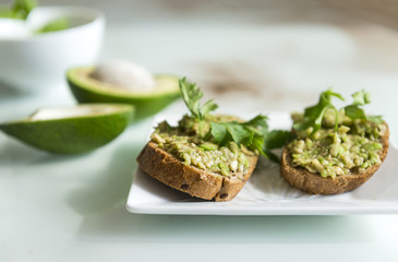 Obraz na płótnie Canvas sandwiches with bread and avocado, a sprig of parsley, useful tasty food