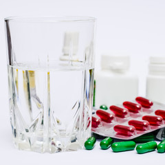 Medicine pills or capsules with glass of water