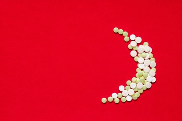 Medicine pills or capsules on red background
