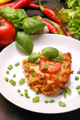 Portion of vegetarian casserole with mushrooms and tomato on white plate