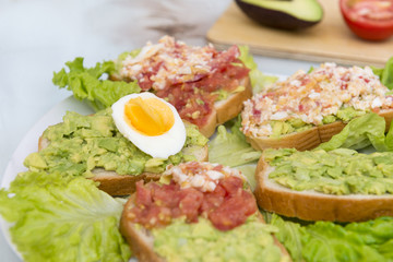 several sandwiches with avocado, tomato and egg, sandwiches on a plate, snack on a plate