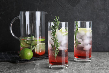 Tasty refreshing lime cocktail with rosemary on table
