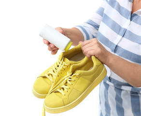 Woman putting powder shoe freshener in footwear on white background, closeup