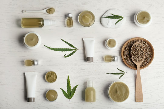 Flat lay composition with hemp lotion on white wooden background