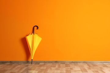 Beautiful umbrella on floor near color wall with space for design © New Africa
