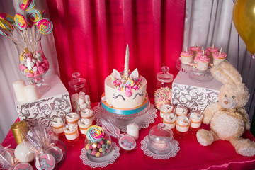 Candy bar for the first birthday for little baby girl. Sweet table and big unicorn cake
