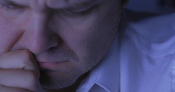 Tired sleepy man is trying to concentrate in night office / close up