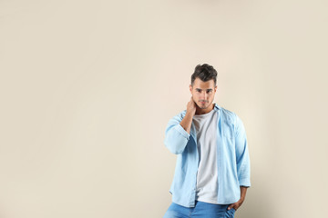 Fototapeta premium Young man in stylish jeans on color background with space for text