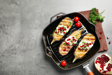 Flat lay composition with grill pan of fried eggplants and space for text on gray table
