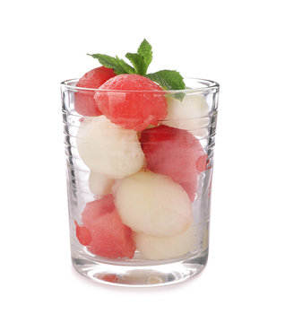 Glass with melon and watermelon balls on white background