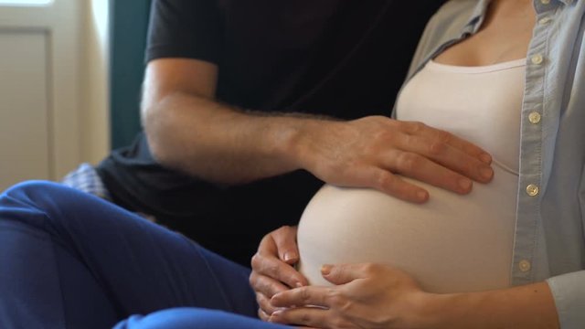 husband stroking pregnant belly