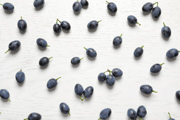 Fresh ripe juicy grapes on white wooden background, top view