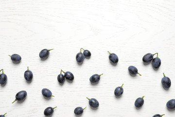 Fresh ripe juicy grapes on white wooden background, top view. Space for text