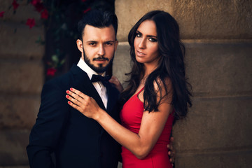 Portrait of an elegant couple in a official evening wear on the background of a classic architecture.