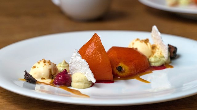 Baked pear with vanilla ice cream close-up on a plate. Cafe GRUSHA, Krasnaya Polyana
