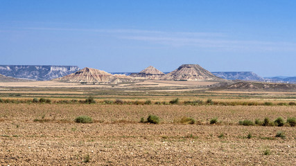 Spain, Bardenas Reales: Panorama view of famous Spanish natural semi desert sierra natural preserve park with Pisquerra rocky mountain chain, wide plains and blue sky - concept travel nature badlands