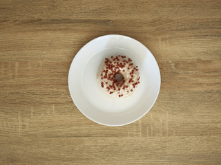 Plate with tasty donut on wooden table