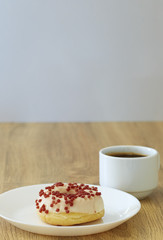 Donut with black coffee on wooden