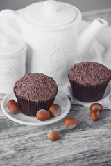 Teapot, chocolate cupcakes, nuts and different decorations