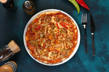 chicken pizza with pepper and olive oil on a wooden background
