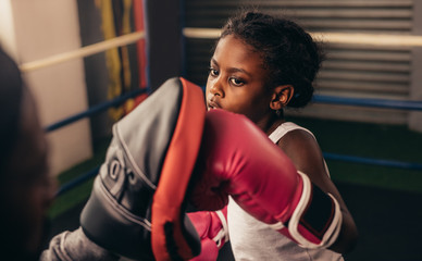 Boxing kid practicing punches on a punching pad