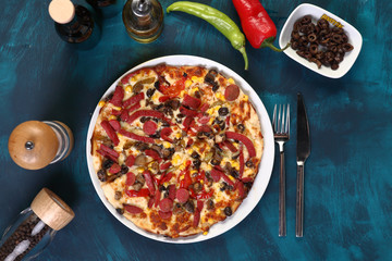 mixed pizza with pepper and olive oil on a wooden background