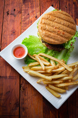 Hamburger with french fries on wooden background