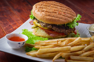 Hamburger with french fries on wooden background