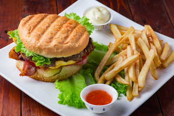 Hamburger with french fries on wooden background