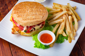Hamburger with french fries on wooden background