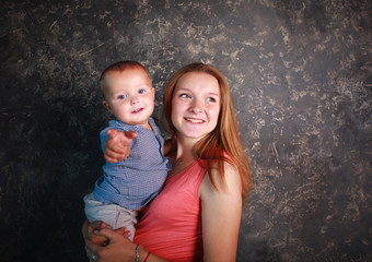 Young mother with her little son in arms happy together