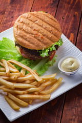 Hamburger with french fries on wooden background