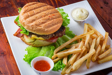 Hamburger with french fries on wooden background