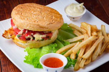 Hamburger with french fries on wooden background