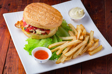 Hamburger with french fries on wooden background