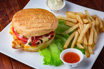 Hamburger with french fries on wooden background