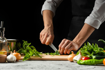 Preparation of tomato sauce by the hands of the chef, steps the process in the kitchen on a black background copy the text of the recipe.The concept of cooking food