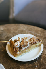 apple pie and swiss meringue, on brown marble table in the cafeteria