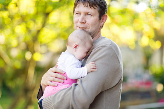 Close-up Of Tired Young Father With Crying Baby Girl. Dad With Daughter Outdoors, Love. Tiny Child Crying. Bonding, Family, New Life.